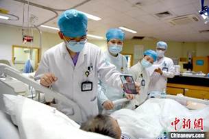 說明: 重癥監(jiān)護室一患者通過“云探視”服務(wù)與家人視頻通話 陳真真 攝